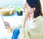 スマートフォンで検査結果を確認する女性